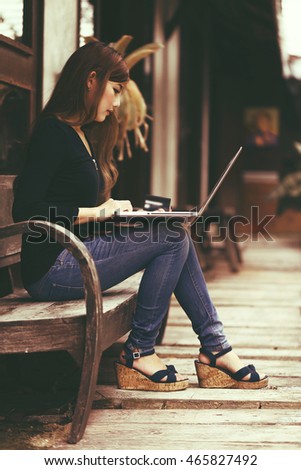 Vintage retro picture of asian shopper girl using laptop for buying online with credit card summer sale fashion product in summer season.