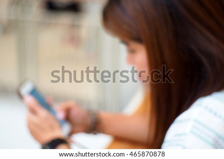 Blurred abstract background of Woman using a smart phone.