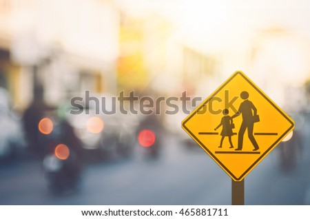 School warning sign on blur traffic road with colorful bokeh light abstract background. Copy space of transportation and travel concept. Vintage tone color style.