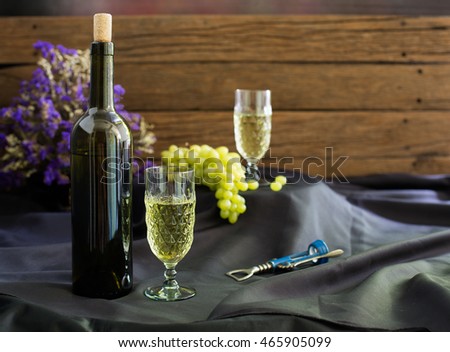 white wine in the glass and bottle wine with bunch of grape on black cloth / selective focus and Still life style