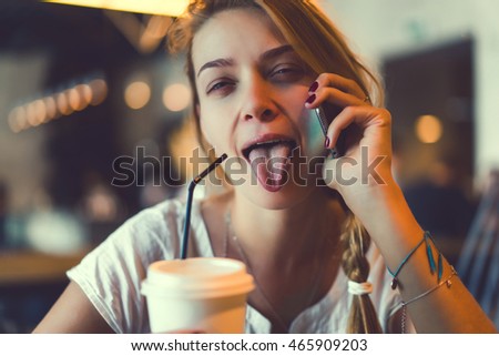 young beauty woman drink coffee and call phone, girl using smartphone, touch screen, happy crazy face, funny, sweet tasty latte, cup tea, hipster outdoor portrait