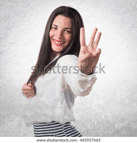 Girl counting three over textured background