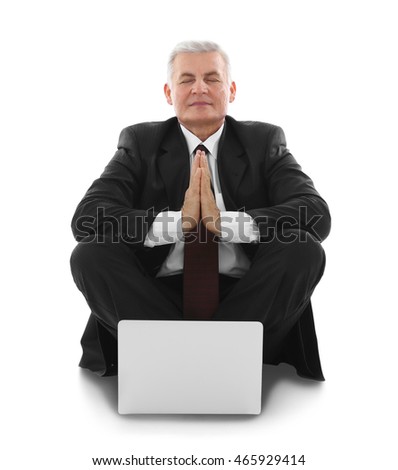 Businessman with laptop relaxing in meditation pose, isolated on white