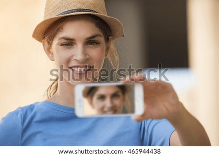 close up of a young woman using an app in her smartphone device to capture a selfie picture
