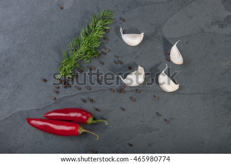 Dill, red peppers, black pepper corn and garlic on a grey slate plate, stock picture