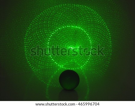 Dark ball with shadow on wall in green laser light