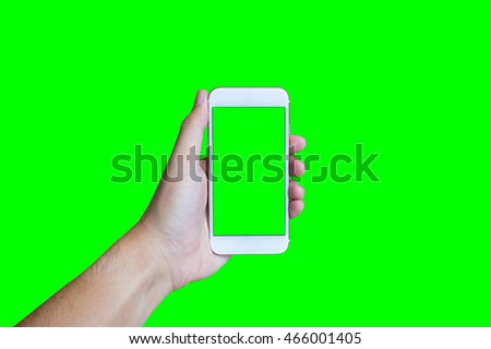 Man's hand shows mobile smartphone with green screen in vertical position isolated on green background - mockup template and clipping path