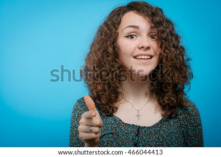 studio portrait of a beautiful girl pointing to the camera