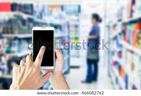 Girl use mobile phone, woman shopping in a mall as background.