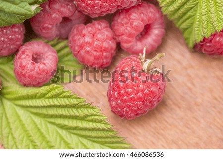 Raspberries in close-up. They are fresh, ripe and red. Tasty food image with juicy berries.