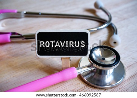 Blackboard with word ROTAVIRUS and pink stethoscope on wooden table. Medical conceptual. Royalty-Free Stock Photo #466092587