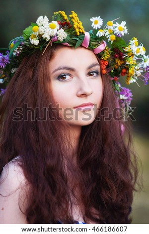 Young beautiful woman wearing a wreath of wildflowers
