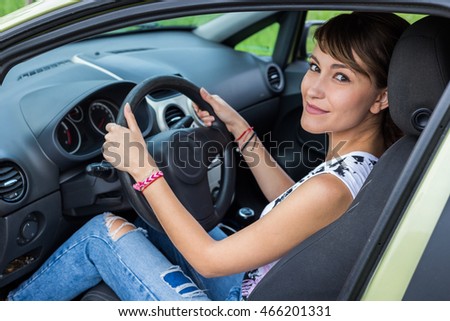 Young caucasian girl in drivers seat. Door open. Smiling. 
