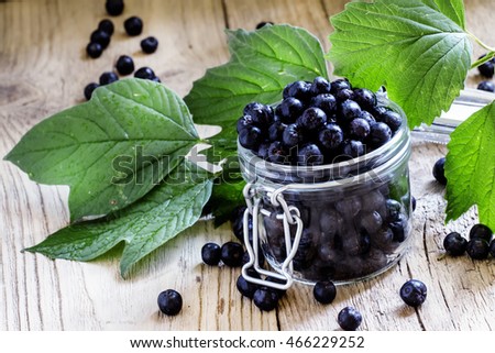 Fresh berries chokeberry in a glass jar, vintage wooden background, selective focus Royalty-Free Stock Photo #466229252