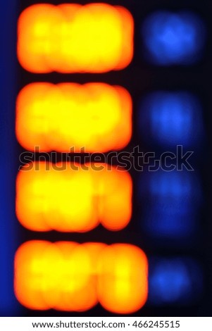 Blurred photo of gasoline station glowing price sign

