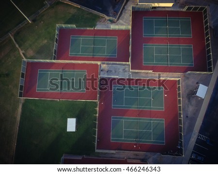 Aerial outdoor tennis court in an athletic complex at Houston, Texas, USA at sunset. Available are baseball fields and parking lots. Urban community athletics program and recreation concept.