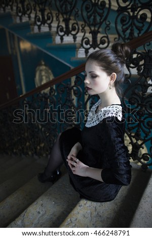 young pretty woman sitting on antique stairs, vintage view