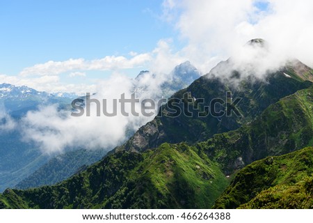 Amazing picture of green mountain landscape, blue sky and white clouds at Krasnaya Polyana or Red Lawn at Sochi. Great nature scenery of mountain range on sunlight at summer day. Sochi, Russia tourism
