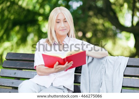 Mature woman reading a book at the park