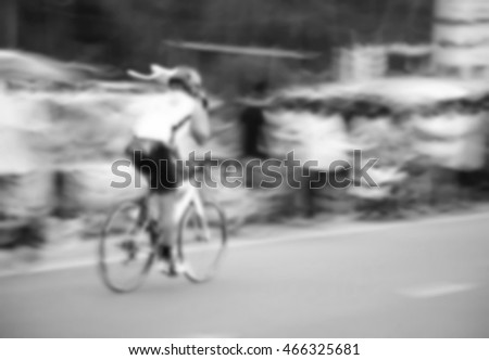 The blurry scene of man cycling bicycle moving on road represent the vehicle and transportation concept related idea.