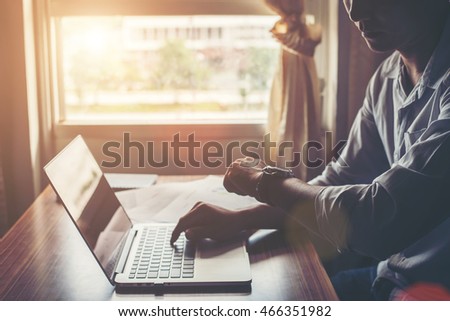 Close-up of male hands using laptop in home.