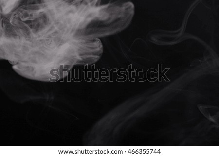 Cloud of smoke on black background. Selective focus.