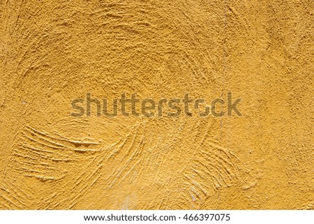 Close-up detail of a rough, yellow-orange skim coat wall. Architecture and design concept.