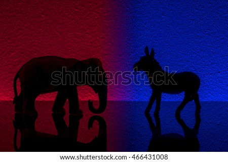 Democrats vs republicans are facing off in a ideological duel on blue and red backgrounds. In American politics US parties are represented by either the democrat donkey or republican elephant