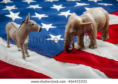 Democrats vs republicans are facing off in a ideological duel on the american flag. In American politics US parties are represented by either the democrat donkey or republican elephant Royalty-Free Stock Photo #466431032