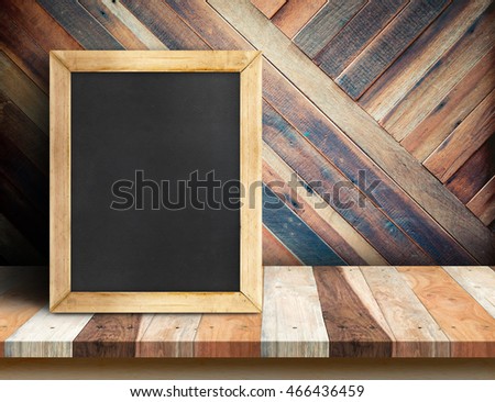 Blank blackboard on plank wooden table top at diagonal tropical wood wall,Template mock up for adding your design and leave space beside frame for adding more content.