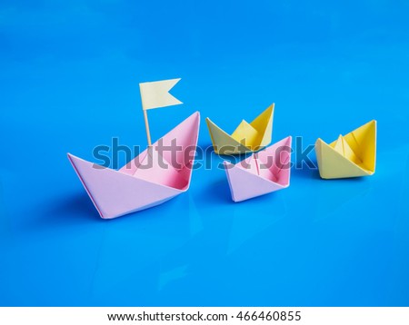 Leadership and team work concept, Craft of paper boat (Origami boat) on blue background
