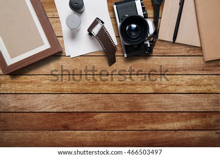 camera and supplies, Blank photo frames on wooden table. Top view