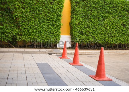 Red striped warning cone on road.