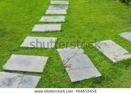 Outdoor marble pathway through green lawn garden