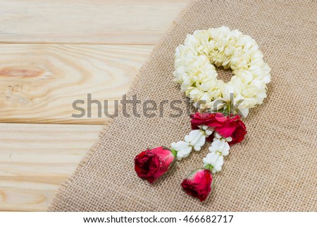 Jasmine garland on jute cloth with wooden floor for thai mother's day.