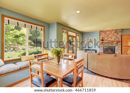 Dining area with wooden table set and cozy sitting place.  View of living room with background fireplace. Northwest, USA