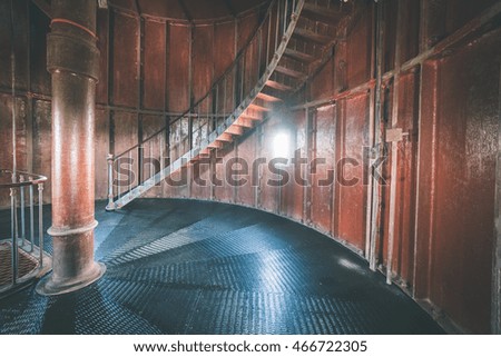 A spiral staircase inside a old wooden lighthouse. - vintage film effect