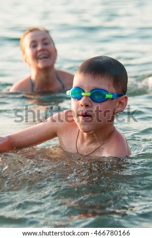grandmother with her grandson merry and joyful swimming in the sea