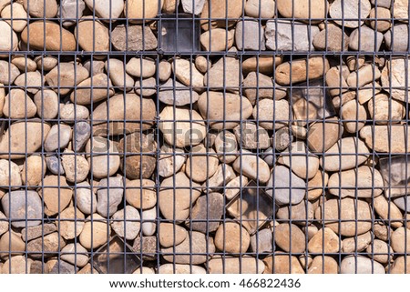 metallic basket net filled by natural stones as a fence