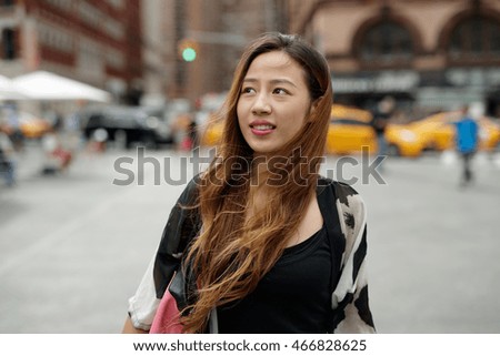 Young Asian woman in city walking smile face


