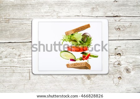 Concept modern cooking. Sandwich with vegetables on your tablet with view from the top.