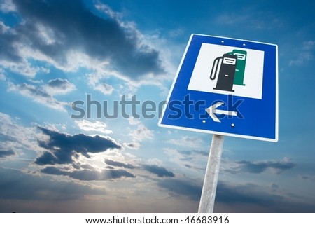 Fuel station sign against cloudy sky