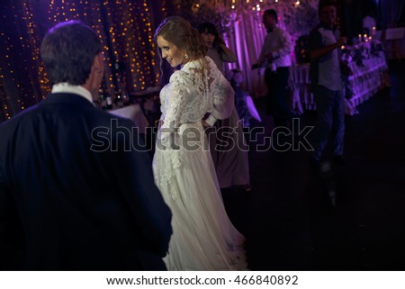 Bride looks brave dancing with a groom in restaurant