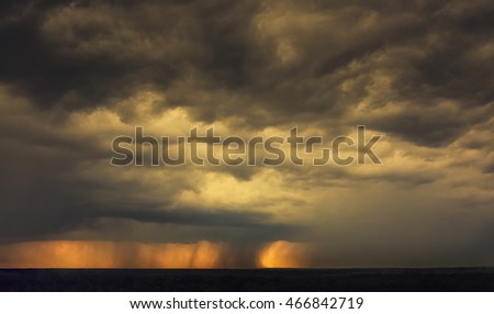 Beautiful sunset sky background. On the horizon is seen rain and large storm clouds.