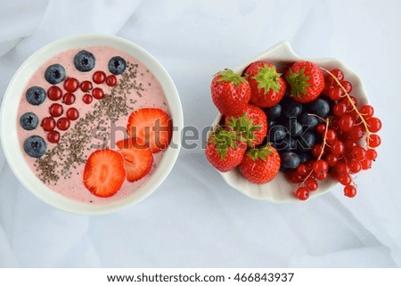 Berry smoothie bowl topped with strawberry, blueberry, red currant and chia seeds

