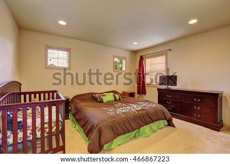 Brown bedroom with crib and vintage chest of drawers. Northwest, USA