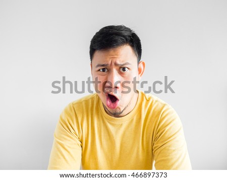 Angry Asian man in yellow shirt.