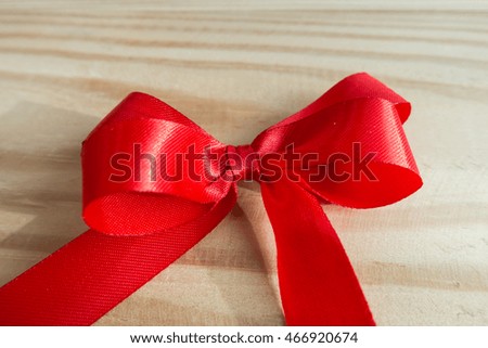 Red ribbon on wood background