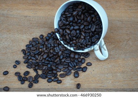 Cup of coffee beans,cup of coffee on brown wooden table