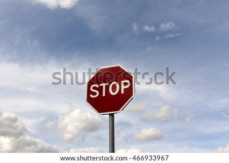 Stop sign against cloudy sky. Traffic signs and symbols.